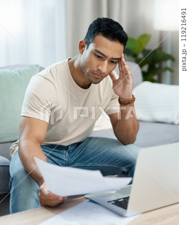 Man, bills and headache on computer and sofa for finance mistake, debt review or taxes stress at home. Young and confused person with documents for budget fail, bankruptcy or inflation news on laptop 119216491