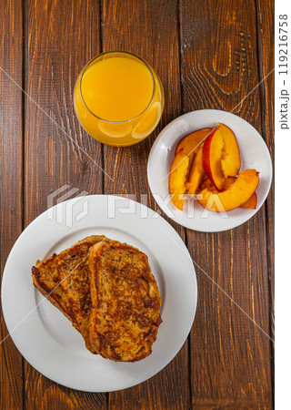 French toast on a plate with blueberries, orange juice, nectarine for breakfast 119216758
