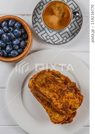 French toast on a white plate with blueberries and coffee for breakfast 119216770