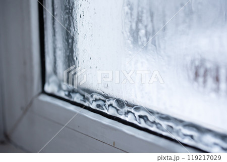 Raindrops on a window pane capture natures beauty, creating a cozy, artistic ambiance Raindrops on a window pane capture natures beauty, creating a cozy, artistic ambiance 119217029