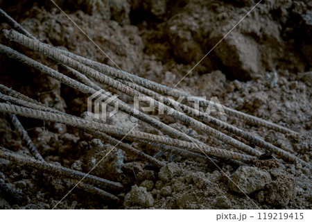 Large pile of earth in which there are many metal reinforcement bars Large pile of earth in which there are many metal reinforcement bars 119219415