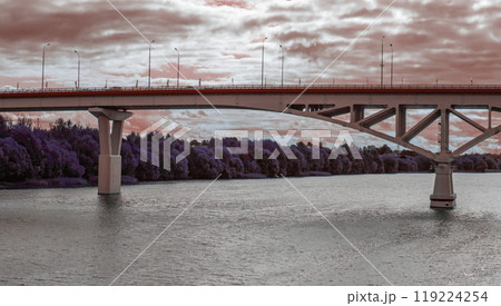 View of a large automobile bridge over a wide river against a cloudy sky View of a large automobile bridge over a wide river against a cloudy sky 119224254