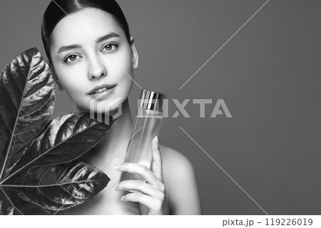 Close up woman face with green exotic leaf Close up woman face with green exotic leaf 119226019