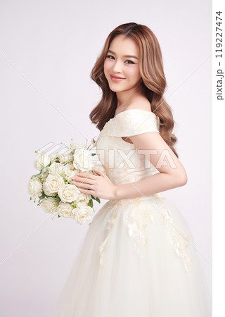 Beautiful young asian woman in wedding dress holding bouquet on white background, Beautiful young asian woman in wedding dress holding bouquet on white background, 119227474