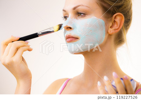 Girl apply green mud mask to face 119227526