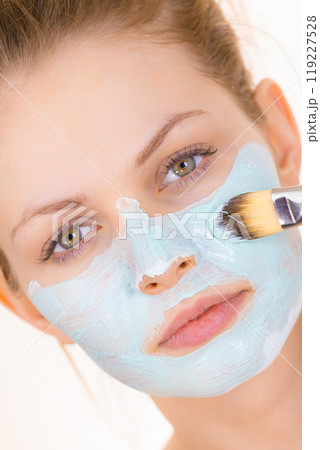 Girl apply green mud mask to face Girl apply green mud mask to face 119227528