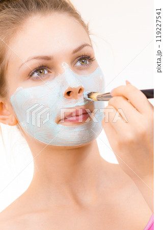 Girl apply green mud mask to face 119227541