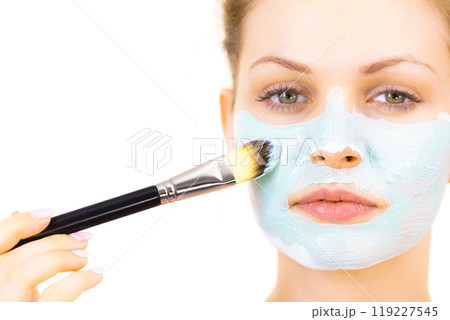 Girl apply green mud mask to face Girl apply green mud mask to face 119227545