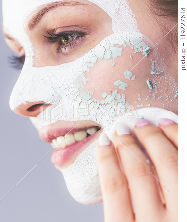 Girl removes dry white mud mask Girl removes dry white mud mask 119227618