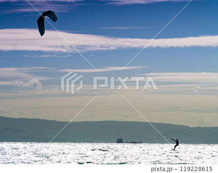 Kite surfer riding waves. Kiteboarding sport. 119228615