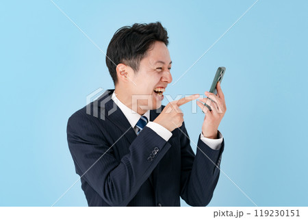 スマホを持って大笑いするビジネスマン 119230151