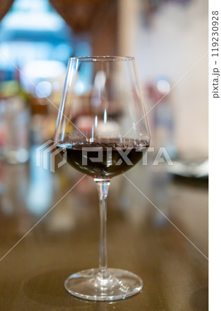 A glass of red wine on the table, with blur background in the restaurant 119230928