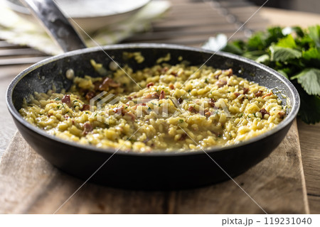 Italian risotto with pancetta, parmesan and parsley in a pan Italian risotto with pancetta, parmesan and parsley in a pan 119231040
