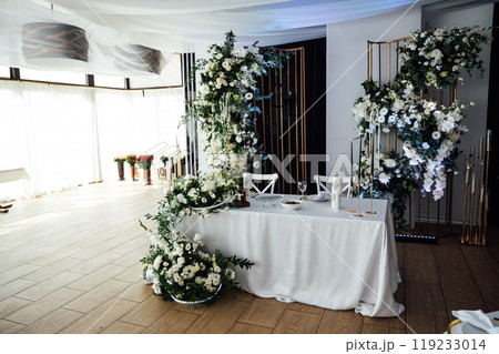 Luxurious restaurant. Luxurious interior, white tables, serving dishes and glasses for guests 119233014