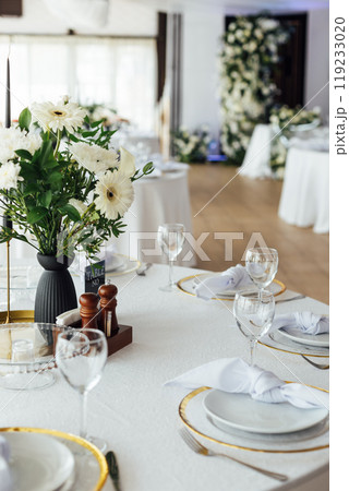 Luxurious restaurant. Luxurious interior, white tables, serving dishes and glasses for guests 119233020