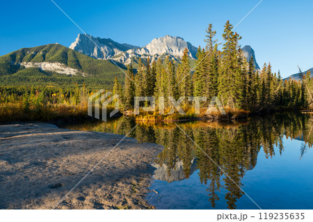 Beautiful scenery of the Canadian Rockies at dawn in autumn. Mountain, forest in yellow and green color reflected on water. Canmore, Alberta, Canada. Mount Lawrence Grassi. Beautiful scenery of the Canadian Rockies at dawn in autumn. Mountain, forest in yellow and green color reflected on water. Canmore, Alberta, Canada. Mount Lawrence Grassi. 119235635