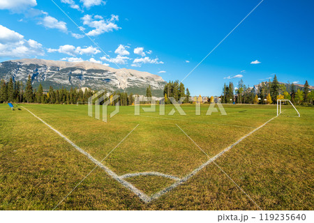Three Sisters Sports Complex Multi-use Field & Playground. Canmore, Alberta, Canada. Canadian Rockies mountain range over the blue sky in the background. 119235640