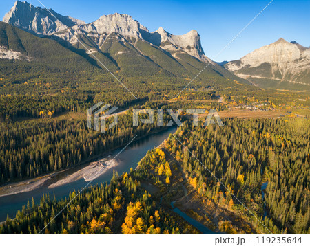 Aerial view of Canadian Rockies mountain range and Bow river forest in autumn morning. Canmore, Alberta, Canada. Mount Lawrence Grassi. 119235644