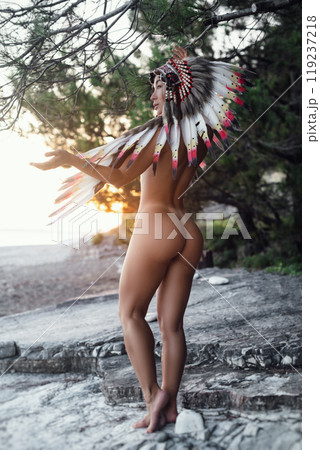 Naked sexy girl in Native American headdresses on the background of nature in the beautiful sunset light 119237218
