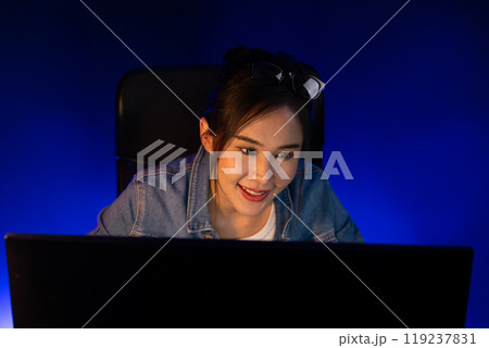 Smiling beautiful asian creative looking pc in sales target online. Stratagem. 119237831