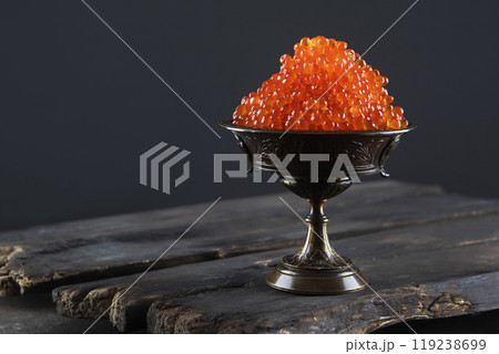 Red caviar. Salmon roe in a vase on a black background. A delicacy. An exquisite snack. A useful omega. Red caviar. Salmon roe in a vase on a black background. A delicacy. An exquisite snack. A useful omega. 119238699