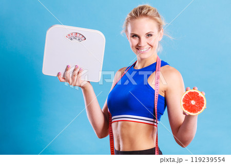 Fit woman holds weight scale grapefruit Fit woman holds weight scale grapefruit 119239554