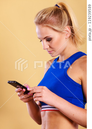 Sportswoman using mobile phone in the gym. Sportswoman using mobile phone in the gym. 119239589