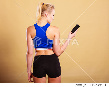 Sportswoman using mobile phone in the gym. Sportswoman using mobile phone in the gym. 119239591
