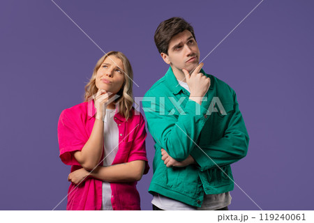 Curious young couple analyzing on violet studio. Mindful man woman searching solution, finding answer. Memory concept Curious young couple analyzing on violet studio. Mindful man woman searching solution, finding answer. Memory concept 119240061