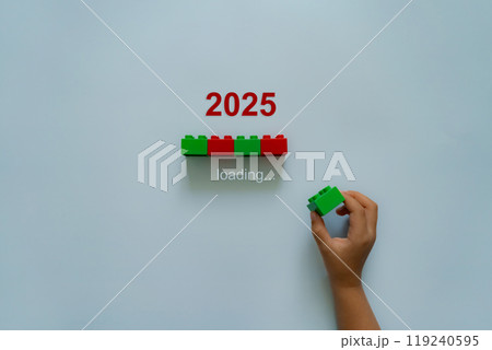 Loading new year 2024 to 2025 with child hand putting plastic block in progress bar.  119240595