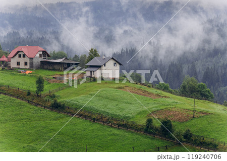 Misty morning in Vorokhta village with scenic view of Carpathian hills and fog-covered mountains 119240706