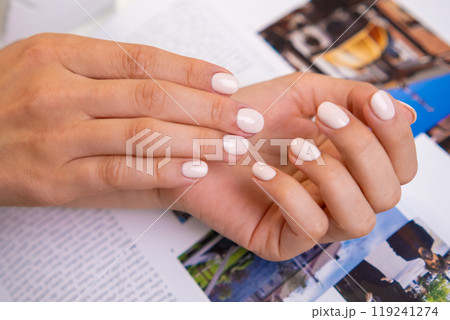 Woman shows off their freshly manicured nails with glossy, light-colored gel polish Woman shows off their freshly manicured nails with glossy, light-colored gel polish 119241274