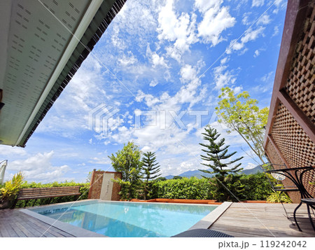 A swimming pool with sunlight reflecting on a clear sky 119242042