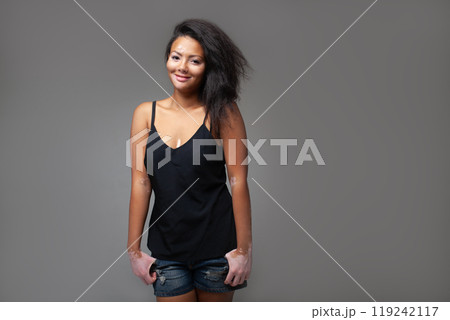 Smiling fashion model with hands in pockets over 119242117