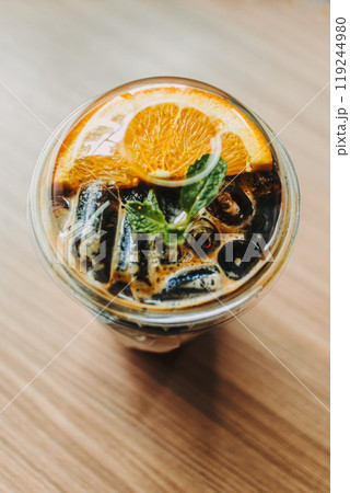 Plastic cup of Iced Orange Americano coffee on the table. 119244980