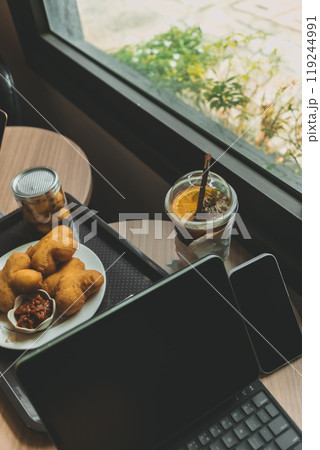 Computer tablet with desserts and Iced drink. Concept of working in cafe. Computer tablet with desserts and Iced drink. Concept of working in cafe. 119244991