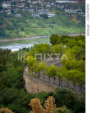 tall-rise buildings in a city hill, big river and winding uphill trail 119249293