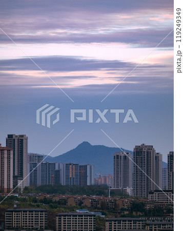 Chongqing city view in sunset, high rise buildings on hills and mountain in the background 119249349