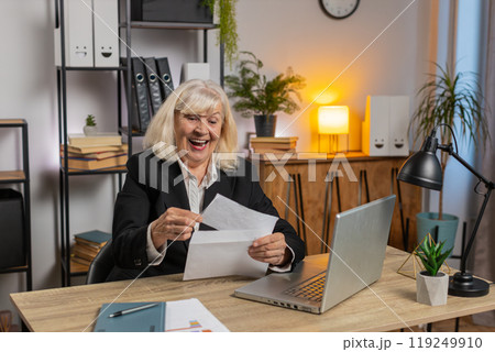 Confused senior businesswoman shrugging shoulders having doubts, no answer at home office desk 119249910