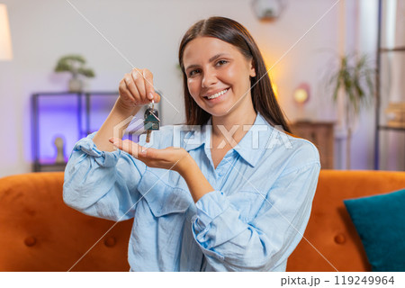 Happy woman real estate agent lifting hand showing the keys of new home buying or renting property 119249964
