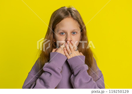 Frightened child girl closing mouth with hands refusing to tell terrible secret, unbelievable truth Frightened child girl closing mouth with hands refusing to tell terrible secret, unbelievable truth 119250129