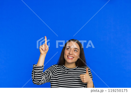 Young woman showing promotion, pointing overhead up on blank space place for your advertisement logo Young woman showing promotion, pointing overhead up on blank space place for your advertisement logo 119250175