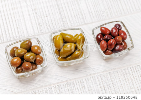 An assortment of various olives presented in a bowl, showcasing different colors, textures, and flavors An assortment of various olives presented in a bowl, showcasing different colors, textures, and flavors 119250648
