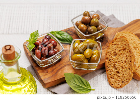 An assortment of various olives presented in a bowl, showcasing different colors, textures, and flavors 119250650