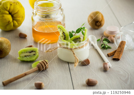 Homemade yogurt in a glass jar with honey, kiwi, nuts. 119250946