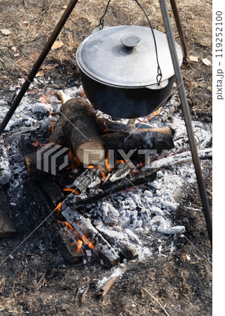 Camping pot with lid. Cooking food on a campfire on a hike. Fire coals. Camping pot with lid. Cooking food on a campfire on a hike. Fire coals. 119252100