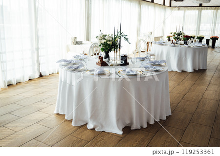 Luxurious restaurant. Luxurious interior, white tables, serving dishes and glasses for guests 119253361