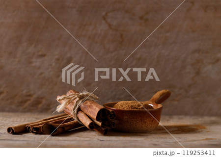 Aromatic cinnamon sticks and powder on wooden table. Aromatic cinnamon sticks and powder on wooden table. 119253411
