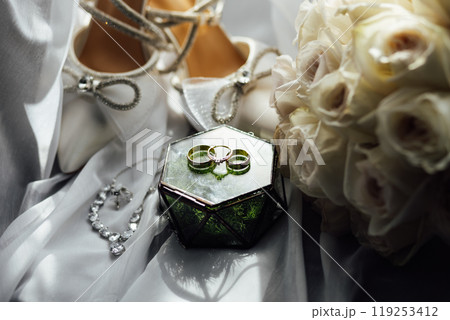 The bride's wedding accessory in the form of a bouquet, wedding gold rings and shoes. The bride's wedding accessory in the form of a bouquet, wedding gold rings and shoes. 119253412