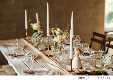Elegant neutral coloured wedding table scape with flowers and candles 119253733